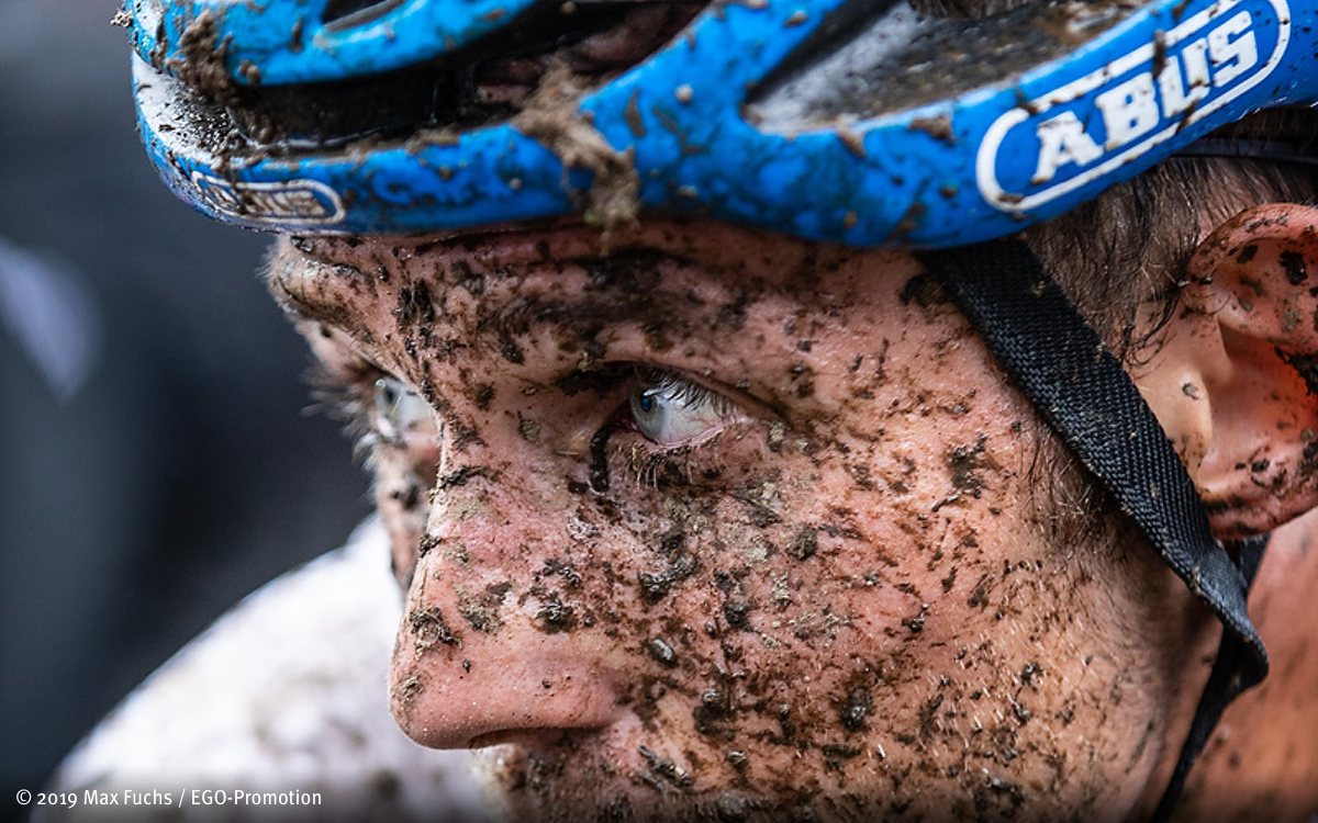 Close-up-Foto von Ben Zwiehoff, Mountainbike Vizemeister, dessen Gesicht voller Schlammspritze ist.