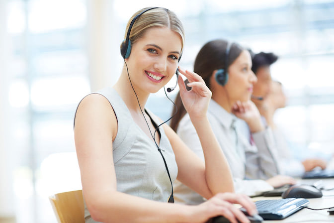 Telefonistin mit Headset am Rechner sitzend