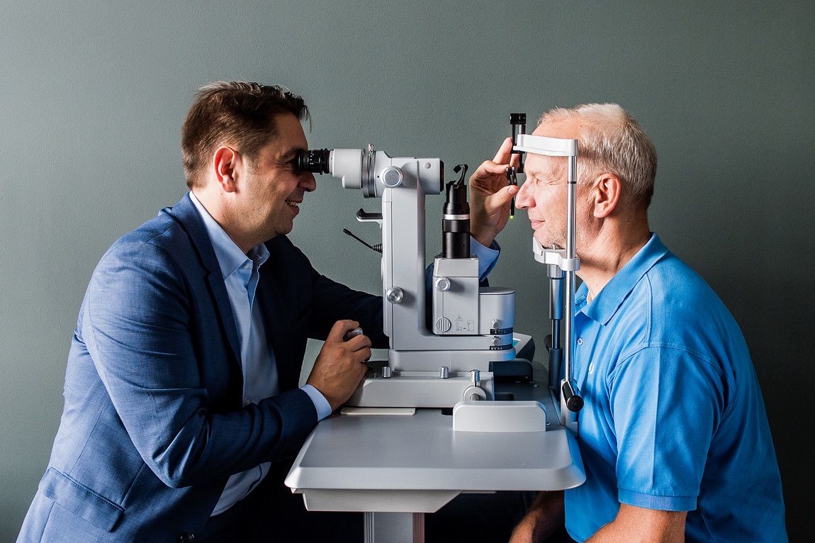 Augenarzt Dr. Kaymak bei der Behandlung eines Patienten.