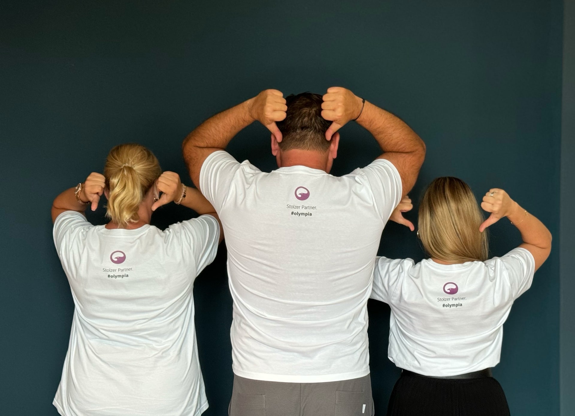 Dr. Breyer und seine Assistentinnen tragen ein T-Shirt mit dem PremiumEyes-Logo und dem Aufdruck: Stolzer Partner Olympia.